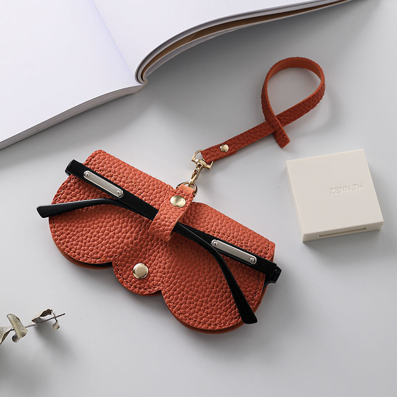 Portable sunglasses holder in orange soft PU leather with metal snap button
