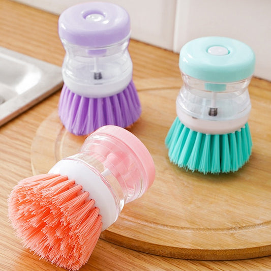 Soap dispenser dish brush that releases soap into the bristles when pressed