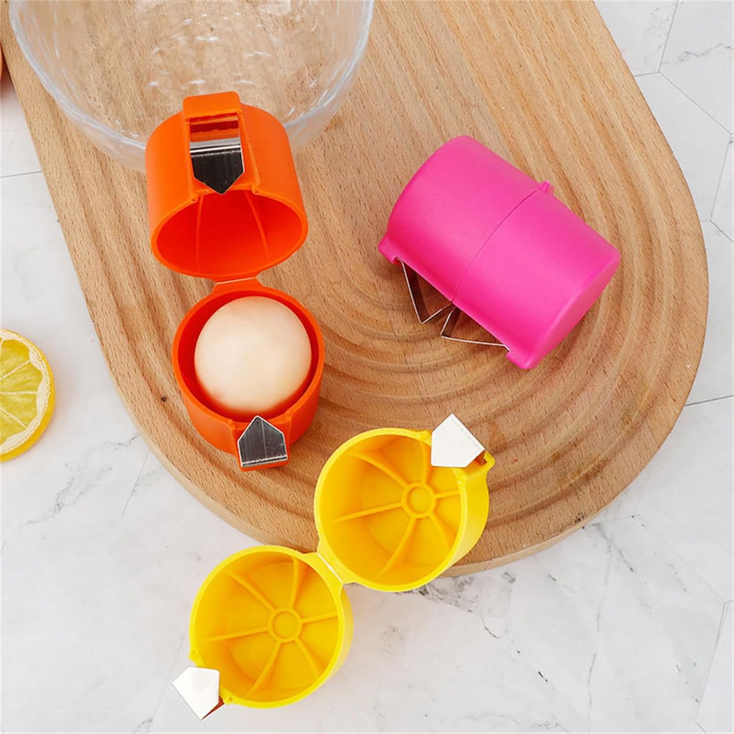 Waf Store Lebanon egg shell crackers in orange, pink, and yellow plastic with stainless steel blades on a wood board.