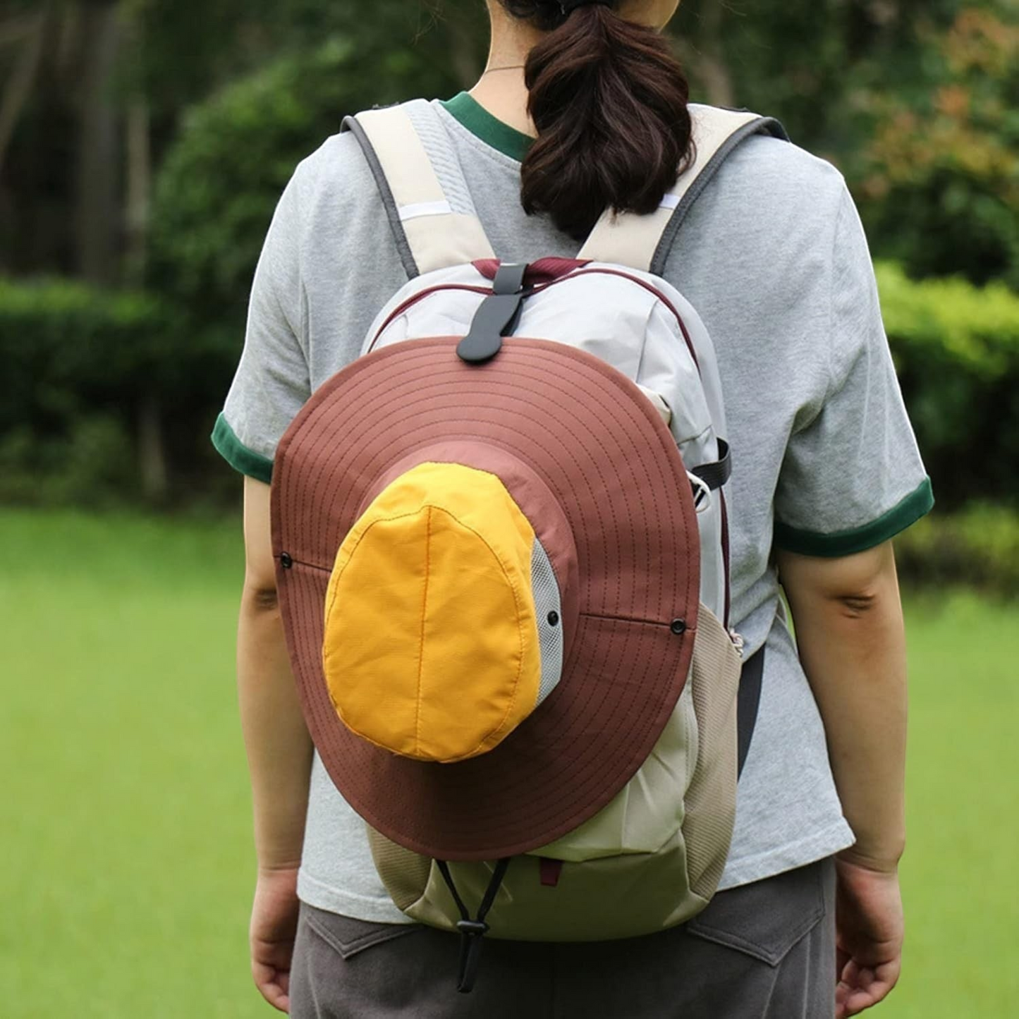 Waf Store Lebanon magnetic hat clip securing a brown and yellow sun hat to a backpack for hands-free travel