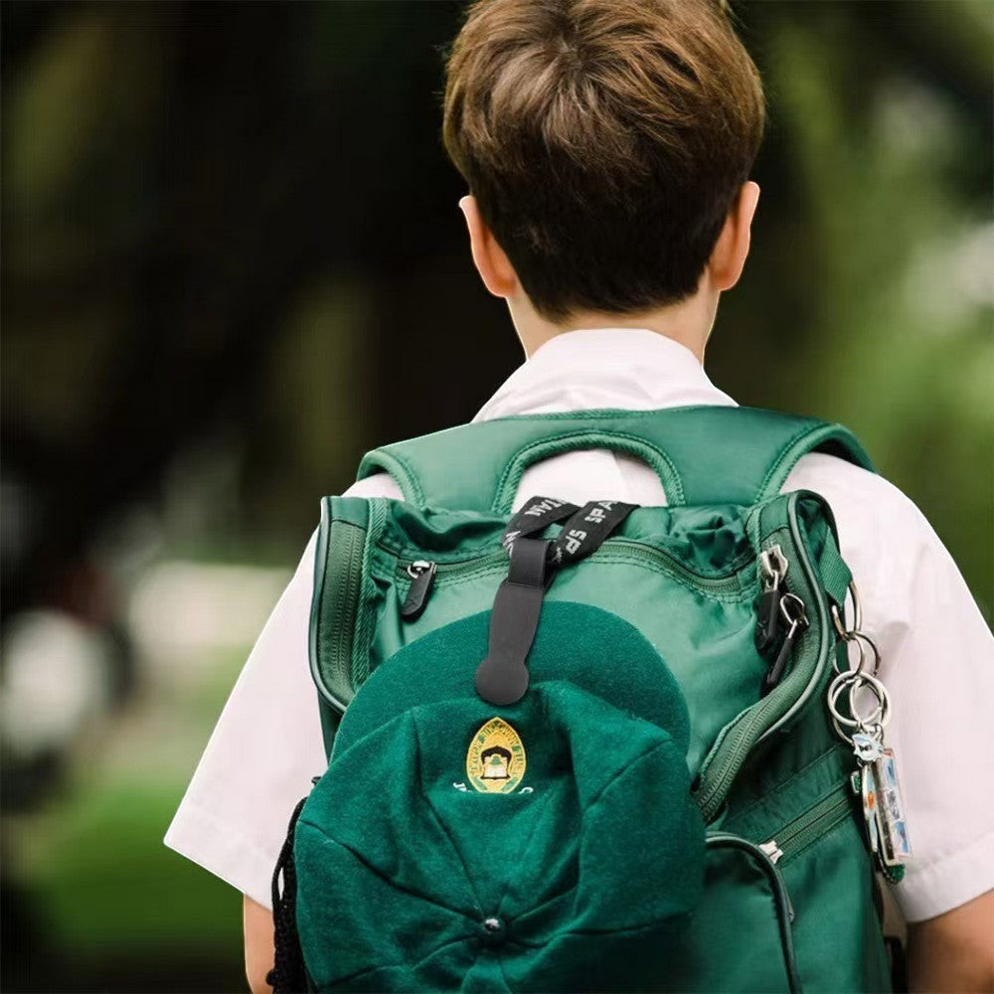 Waf Store Lebanon black silicone magnetic hat clip attached to a green backpack carrying a matching green cap