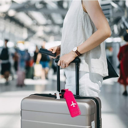 Waf Store Lebanon pink PVC luggage tag attached to a suitcase handle in a busy airport terminal