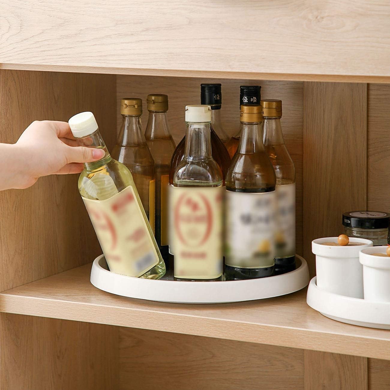 Waf Store Lebanon white rotating spice organizer turntable holding glass condiment bottles inside a wooden cabinet.