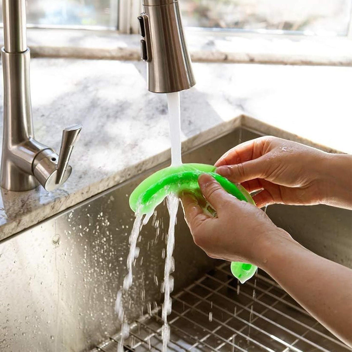 Waf Store Lebanon green silicone food separator being rinsed under a kitchen faucet for easy cleaning