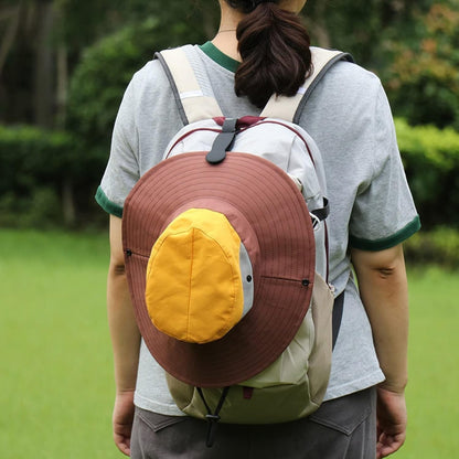 Waf Store Lebanon black silicone hat clip securing a brown and yellow sun hat to a backpack outdoors