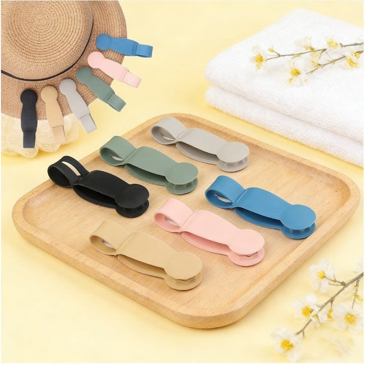 Waf Store Lebanon portable silicone hat clips in assorted colors displayed on a wooden tray with a straw hat