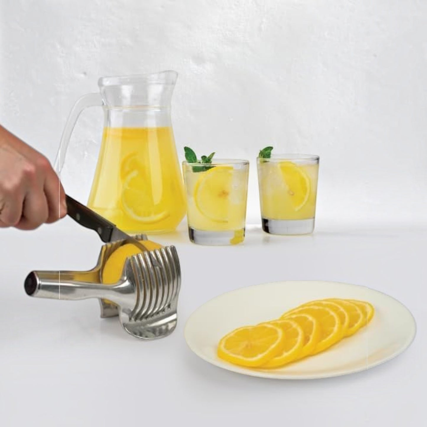 Waf Store Lebanon stainless steel lemon slicer holding a lemon with a knife, next to lemonade and sliced lemons.
